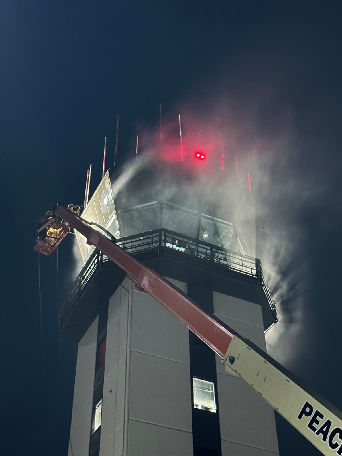 Lamphier & Company crew pressure washing FAA control tower cab at night using rotoblasting tips